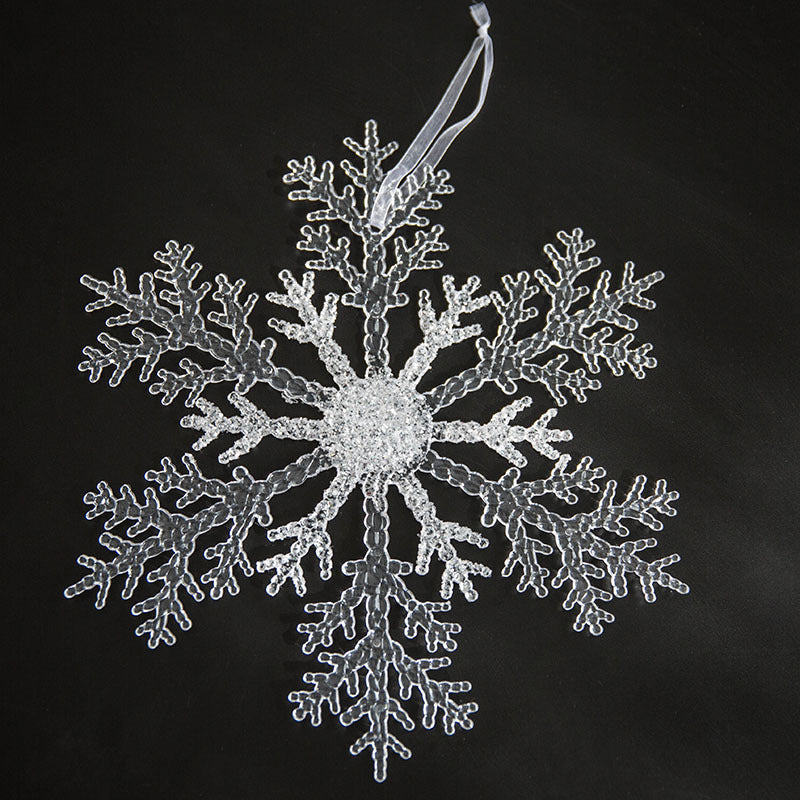 Christmas tree decorated with various ornaments including transparent snowflake pendant