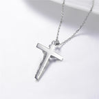 Close-up of silver cross pendant showcasing intricate design