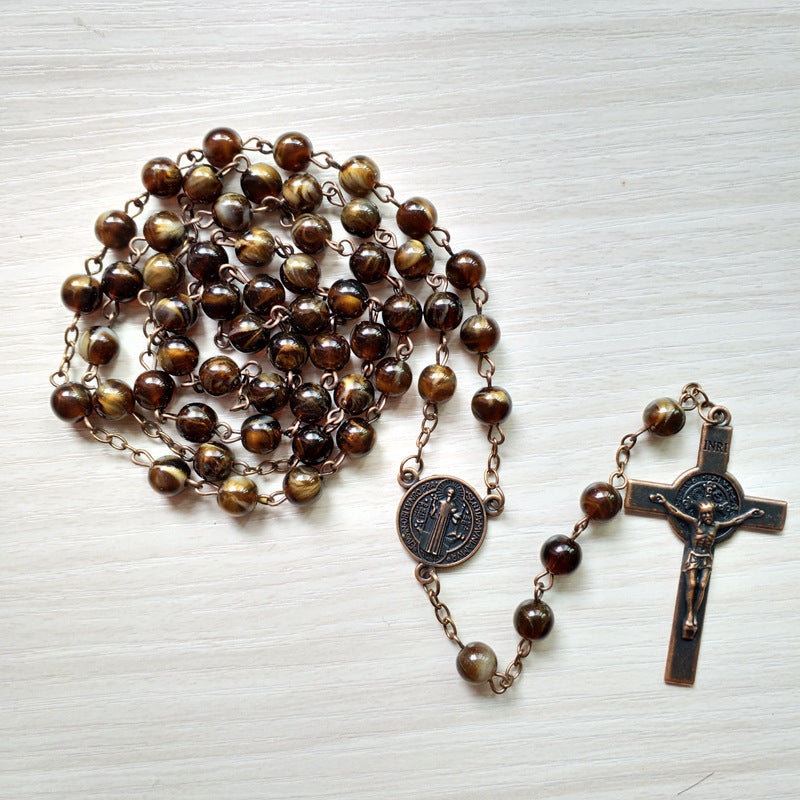Unisex rosary style necklace with benedict cross pendant displayed flat
