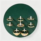Assorted gold-tone rings from the 8-piece cross and sun set arranged together