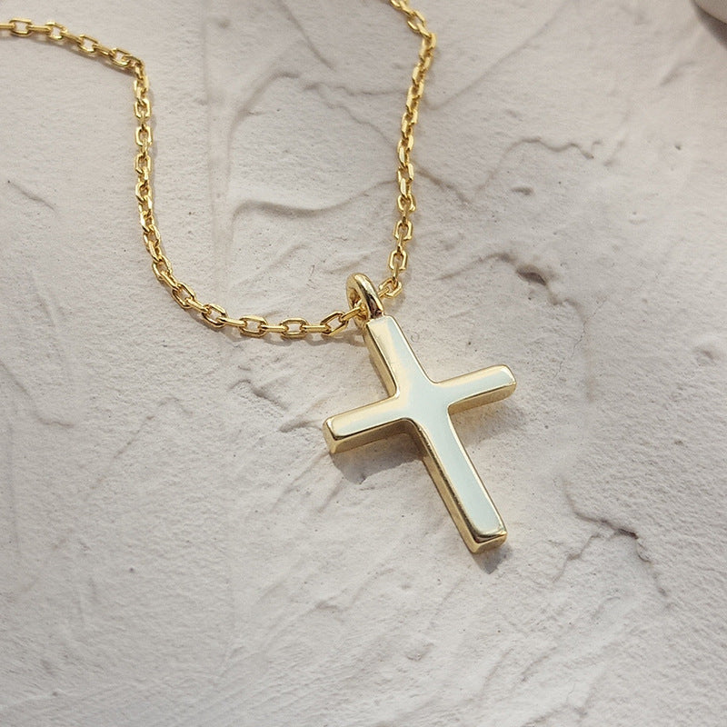 Silver cross pendant necklace laid flat for measurement reference