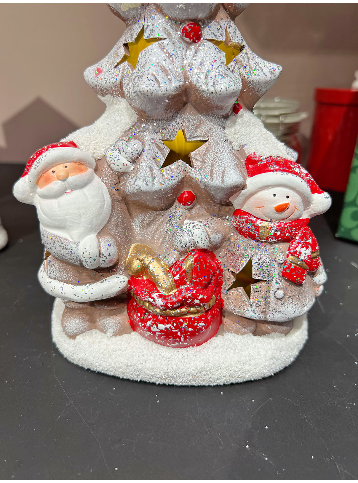 Christmas ornament featuring glowing ceramic houses in winter scene