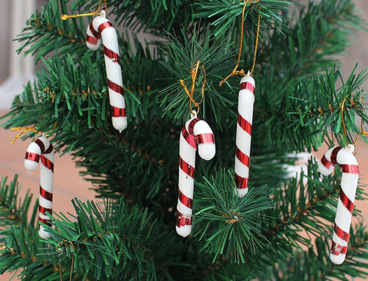 Tri-color candy cane Christmas ornaments arranged on festive background