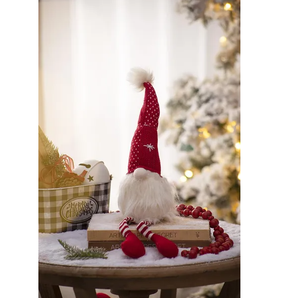 Close up of a cheerful Christmas gnome with fluffy white beard and red and white striped hat