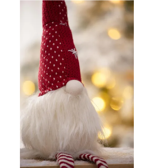 Holiday gnome figures arranged on a mantel with other Christmas decorations