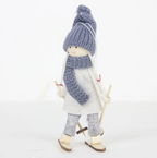 Wooden ski doll ornament in red dress with white hat on snowy surface