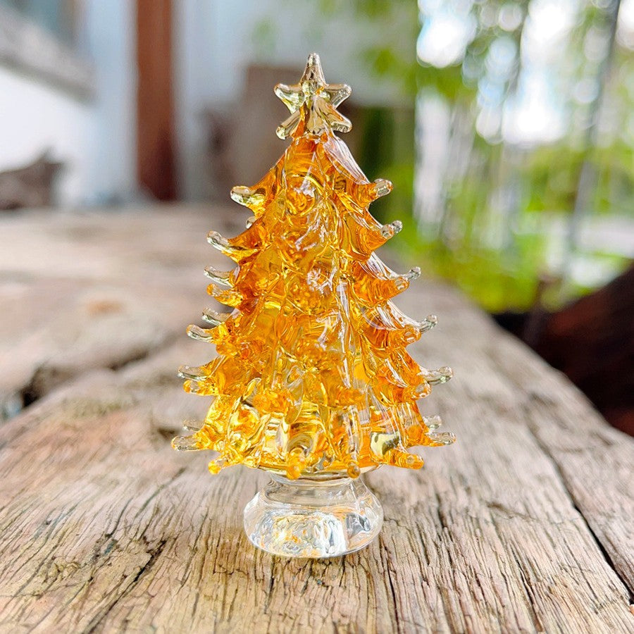 Pink crystal Christmas tree ornament displayed on evergreen branches