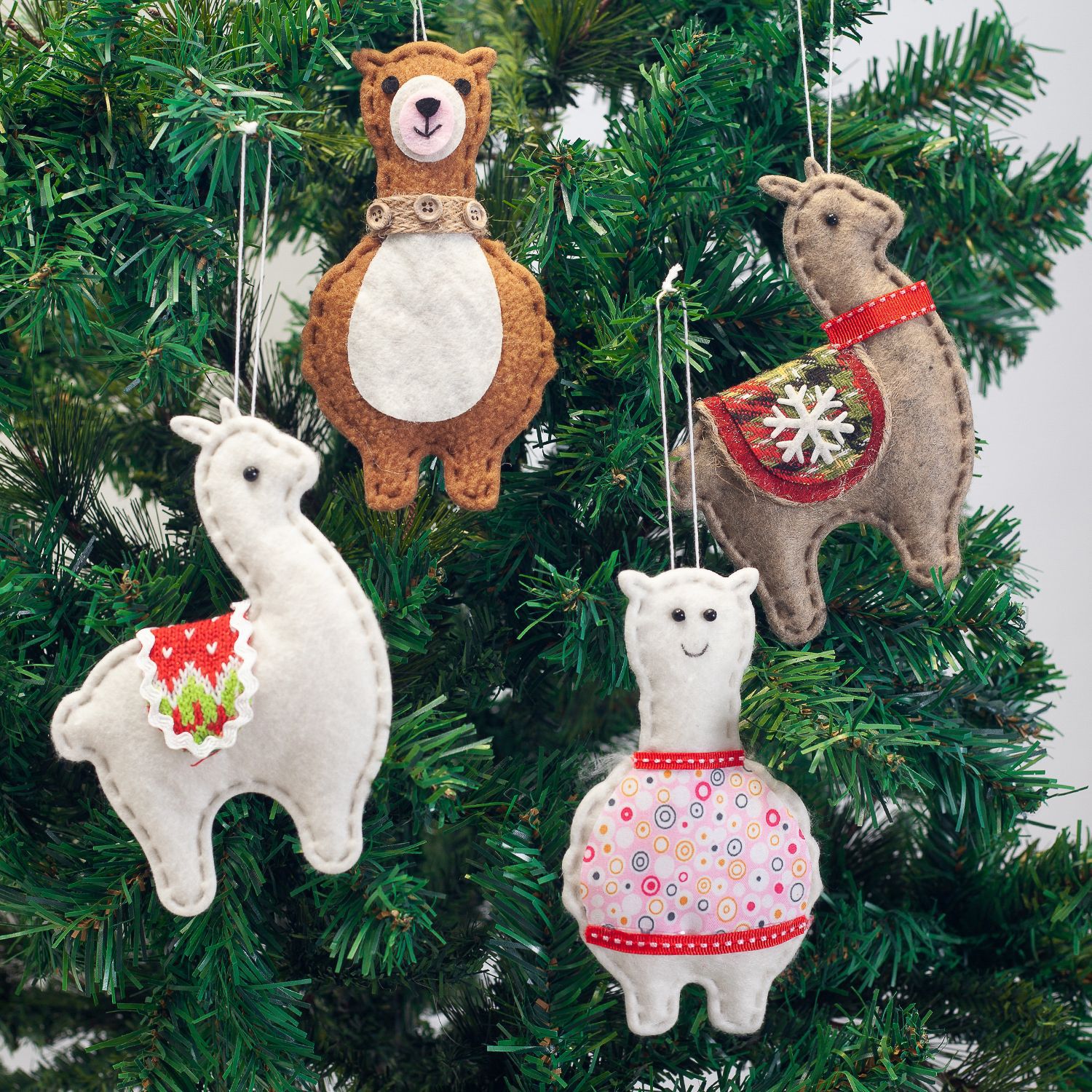 Alpaca wearing Christmas attire beside decorated tree pendant ornament