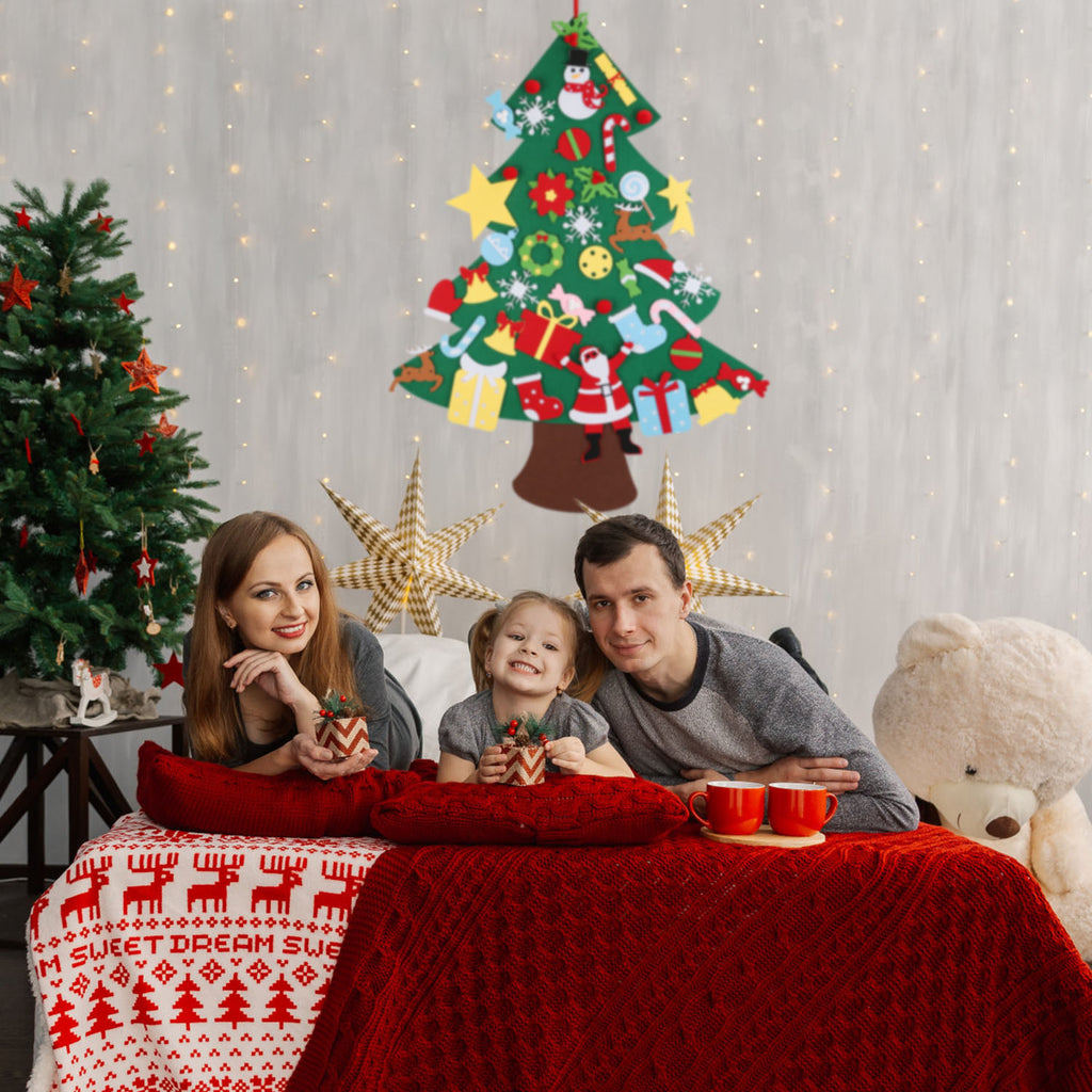 Child placing ornaments on a felt Christmas tree wall hanging decoration