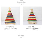 Rotating Christmas tree building block decoration displayed on a wooden desk with festive greenery