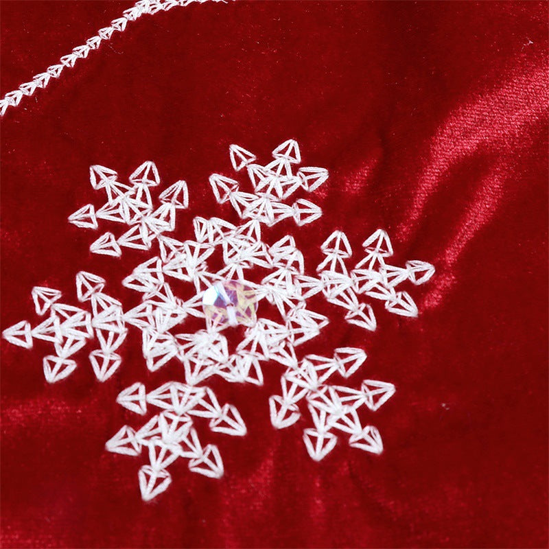 Full view of red velvet snowflake tree skirt displayed as Christmas home decor accent