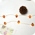 Close-up of soft glowing warm white LED bulbs on Christmas string lights, battery powered