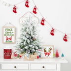 Close-up of green flocked branches with pine cone decorations on mini tree