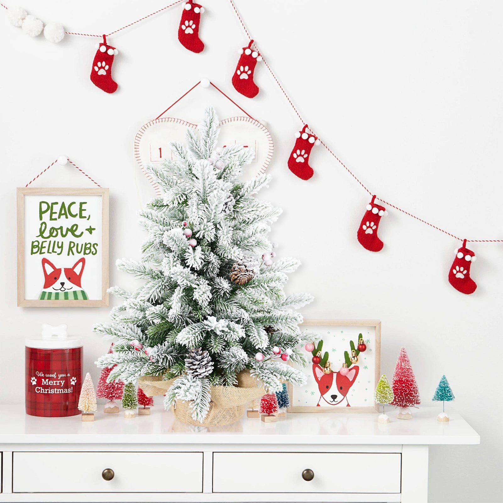 Close-up of green flocked branches with pine cone decorations on mini tree
