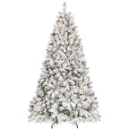 Hand placing star ornament atop flocked Christmas tree