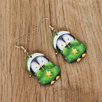 Cute wooden penguin earrings with red and green accents close up