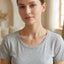 Gold cross pendant necklace with textured horizontal ridges on a delicate chain