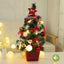 Decorated mini Christmas tree in gold with LED string lights and festive ornaments for desktop display
