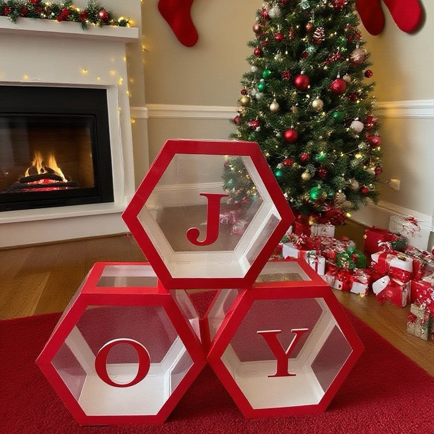 Close-up view of Joy lettered hexagonal balloon box in warm Christmas setting