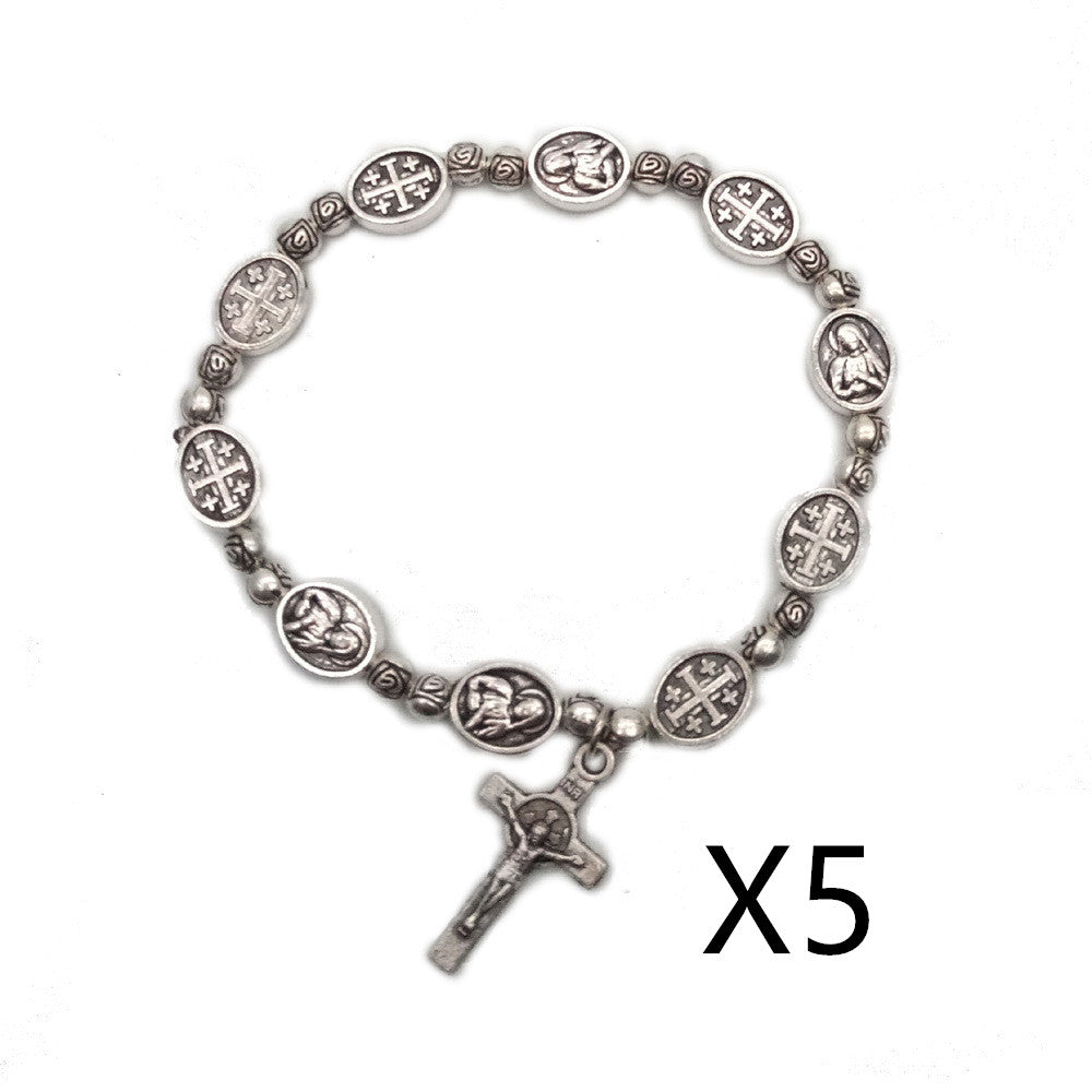 Detailing of small cross pendant on beaded bracelet