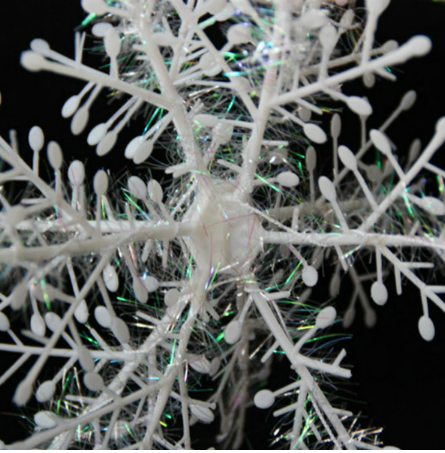 Set of 3D Christmas snowflake string decorations hanging in festive display