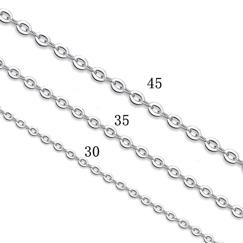 Person wearing simple silver cross pendant necklace