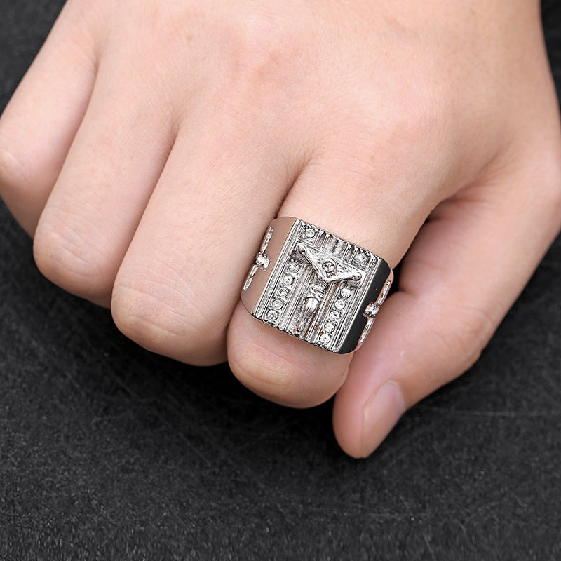 Men's vintage Jesus cross ring displayed at an angle on a dark surface