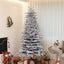 Snow-flocked artificial Christmas tree with warm white LED glow in living room setting