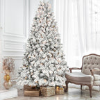 Mixed flocked Christmas tree with warm glowing lights surrounded by holiday decorations