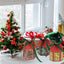 Stack of colorful Christmas tree bell paper treat boxes with red green yellow blue ribbons arranged on rustic surface