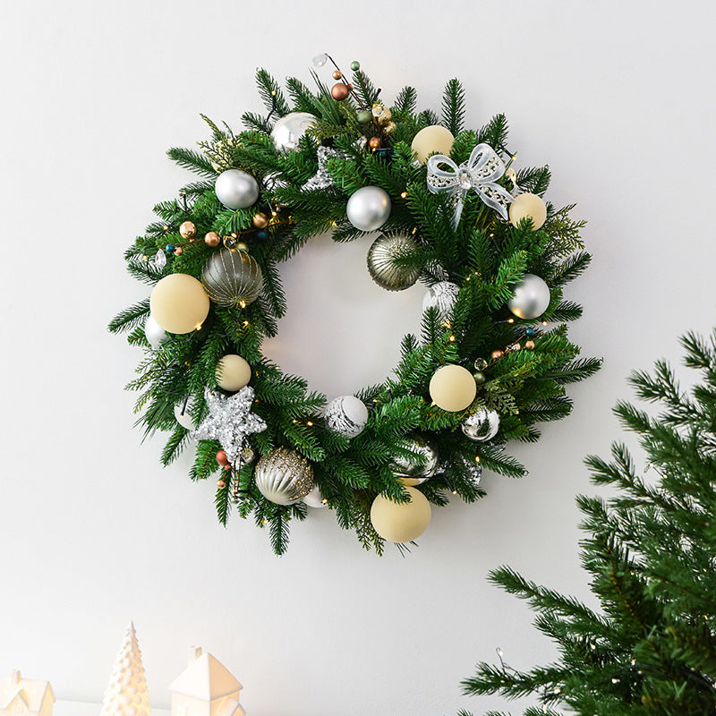 Green pine leaf garland with warm lamp lights hanging on a door at Christmas Main image