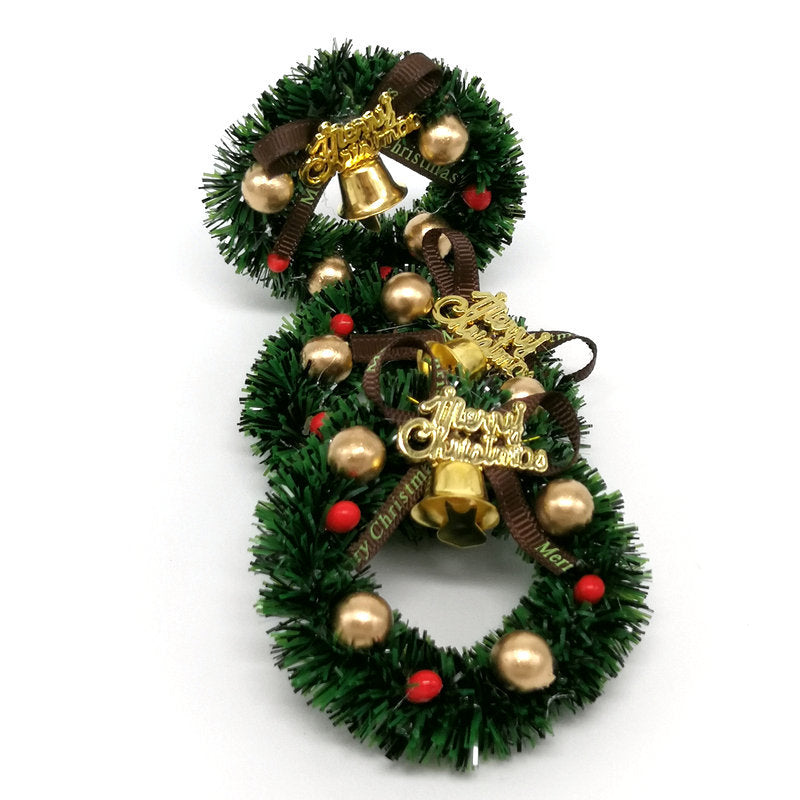 Close-up of festive mini wreath featuring iron bells and ribbon decorations