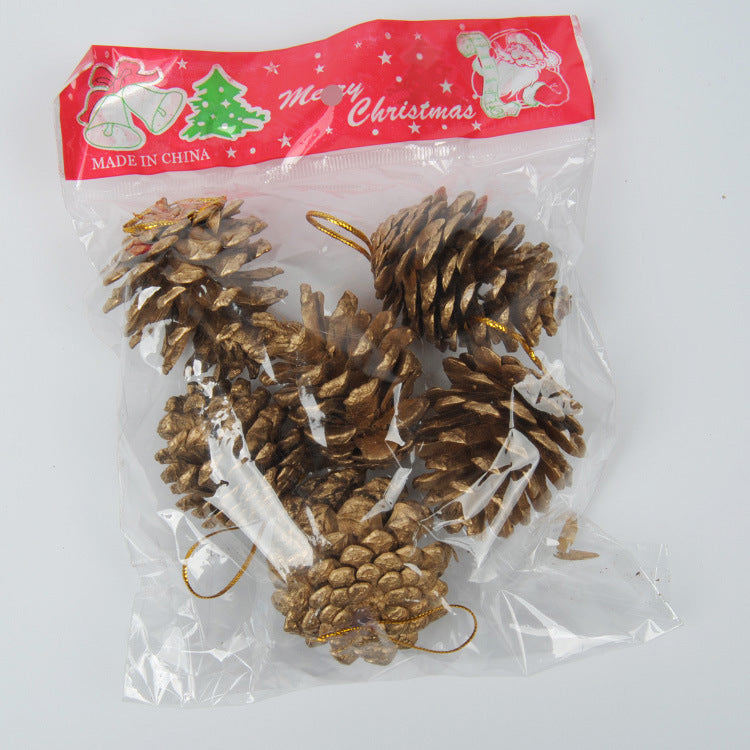 Assorted gold and silver pine cone pendants styled with evergreen branches and red berries