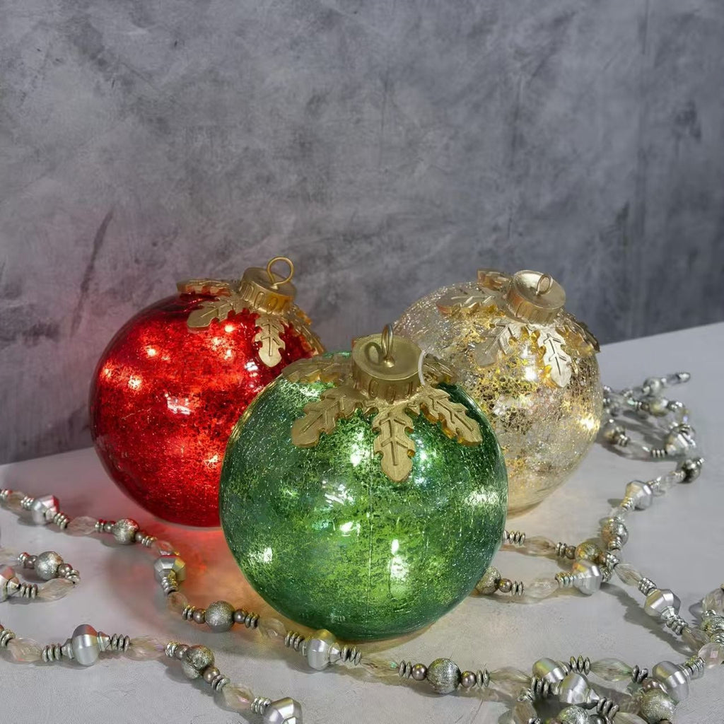 Three Christmas decorations with warm light glow against dark background