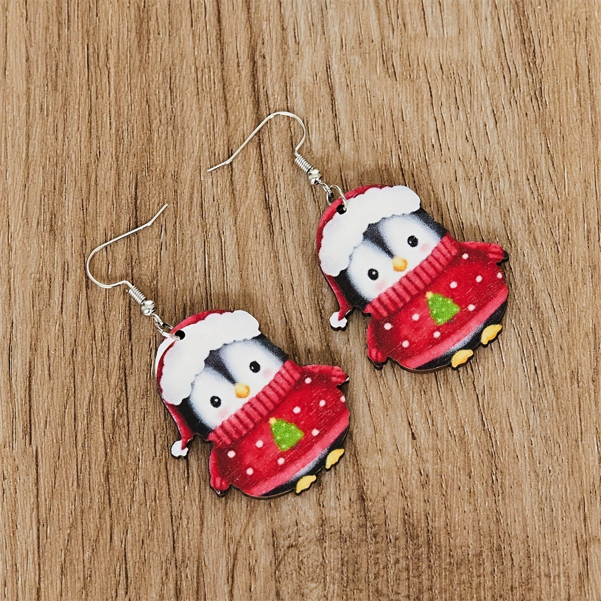 Whimsical Christmas penguin earrings on white background