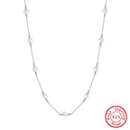 Woman wearing sterling silver pearl cross chain necklace