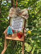 Heaven Chair ornament displayed among evergreen branches and ornaments