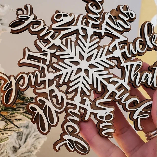 Wooden snowflake letter pendant displayed as Christmas tree ornament with warm holiday ambiance
