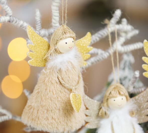 Christmas angel ornament hanging on tree with warm holiday lights