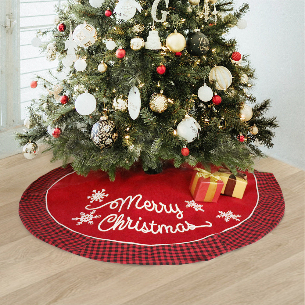 Plush black and red plaid Christmas tree skirt draped around a decorated holiday tree