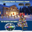Solar Christmas tree stake light glowing warmly in a nighttime winter garden setting with soft white lights