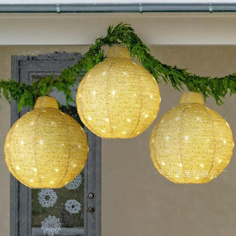 Set of three glowing Christmas round lantern pendants in red, gold and green hanging together on a festive background