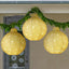 Set of three glowing Christmas round lantern pendants in red, gold and green hanging together on a festive background