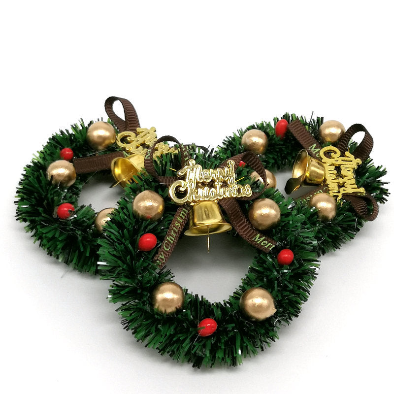 Mini Christmas wreath with bells and ribbon on dark background
