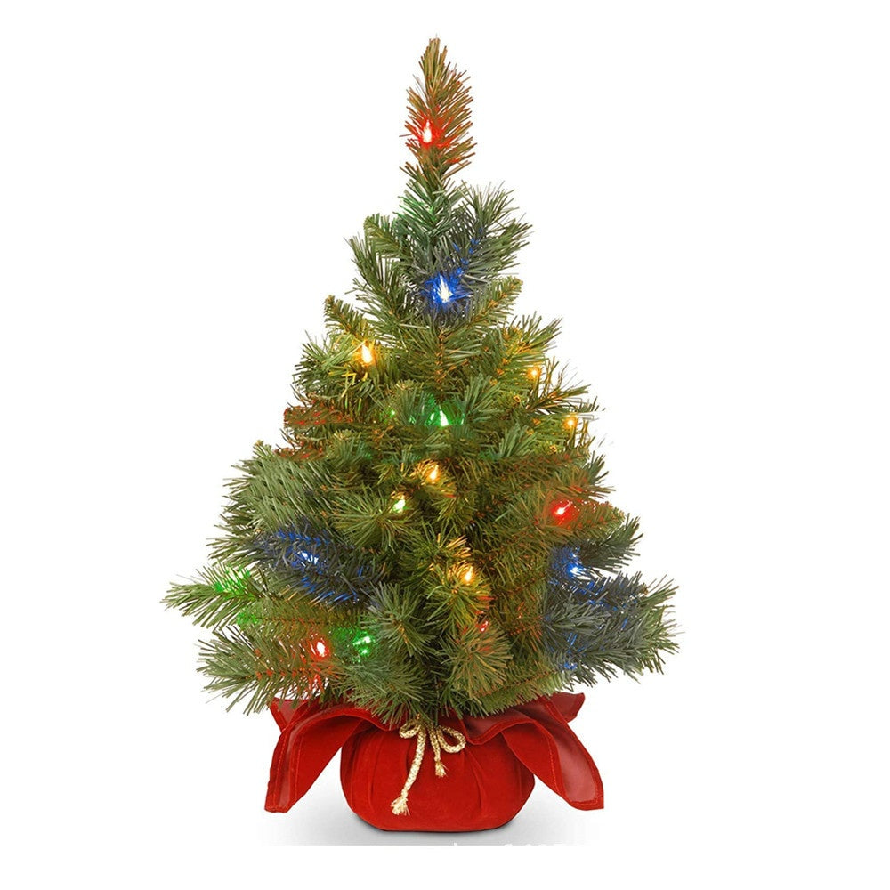 Small PVC Christmas tree on wooden surface for mantle display