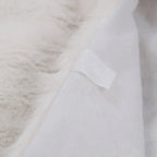 Close-up of white plush Christmas tree skirt hem displaying quality stitching and soft fabric for indoor holiday use