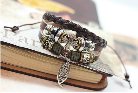 Close-up of cross and fish motifs on leather band