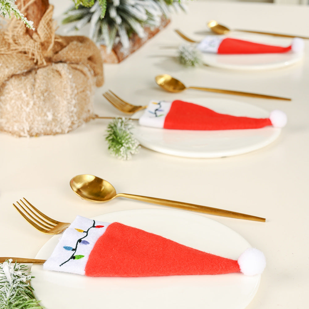 Festive red Christmas hat with matching cutlery on table