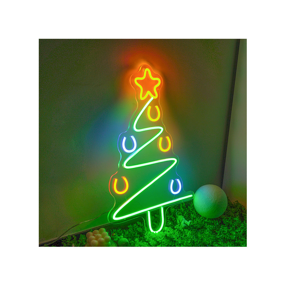 Christmas tree neon sign glowing on wooden surface with decorative ribbon