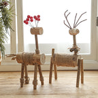 Set of two hand carved solid wood deer Christmas ornaments in festive setting